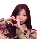 A young woman with long hair makes a heart shape with her hands and puckers her lips for a kiss.