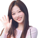 A young woman with long dark hair smiles and waves her hand.