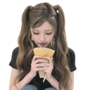A girl with pigtails holding a drink and sipping it with a calm expression.