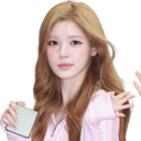 A young woman with long brown hair wearing a pink top waves her hand with a friendly expression.
