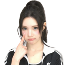Young woman pointing to her eye with a playful and suspicious expression.