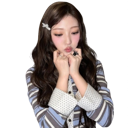 A young woman looking downward with a shy expression while holding her hands near her chin.
