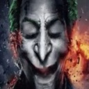 Joker with green hair and white face paint wearing a sinister, closed-eye expression against a dark, fiery background.
