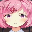 Natsuki with pink hair and a skeptical, annoyed facial expression.