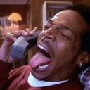 Marlon Wayans licking a telephone receiver with his eyes closed in a comedic expression.