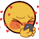 A yellow smiley face with red cheeks and hearts, giggling while holding a smartphone to its mouth.