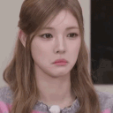 A woman with long brown hair making a sad, pouting expression.