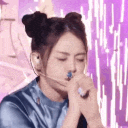 Young woman with space buns makes a heart shape with her hands in a repeating animation.