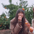 A young girl with long dark hair eats a small snack while a red heart icon floats above her head.