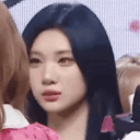 Young woman with long dark hair looking at the camera with a skeptical and confused expression.