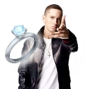 Eminem pointing his finger at a large diamond engagement ring floating in the air.