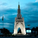 The Monument de l'Indépendance in Bamako stands illuminated against a deep blue evening sky.
