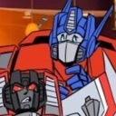A large blue and red robot looks concerned while shielding a smaller, grumpy-looking dark robot.