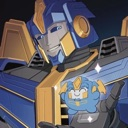 A large blue and gold robot gently holds a small, cute chibi creature in its hand.