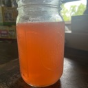 A clear glass mason jar filled with a vibrant pink liquid.