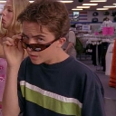 Malcolm peering over his sunglasses with a judgmental and suspicious expression.