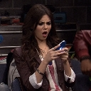 Victoria Justice looking at a smartphone with a shocked and confused expression.