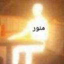 A person sitting at a table completely engulfed in bright, blinding golden light with the Arabic word for illuminating writt…