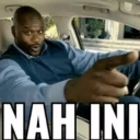 Shaquille O'Neal sitting in a car and pointing directly at the viewer with a serious expression.