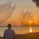 Giant feet with white painted toenails hovering over a sunset city skyline.