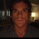 Dexter Morgan staring directly at the camera with a serious and intense expression.