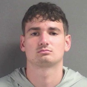 Young man with a neutral, unimpressed expression looking directly into the camera.