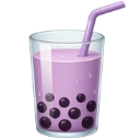 A glass of purple bubble tea with dark tapioca pearls and a straw.