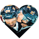 Two hockey players wearing helmets sharing a kiss inside a heart-shaped frame.