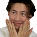 Person holding their hands against their cheeks with a coy, smiling expression.