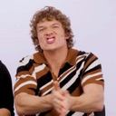 Man making a finger gun gesture with an intense, aggressive facial expression.