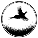 A black silhouette of a pheasant flying over grass inside a circular border.