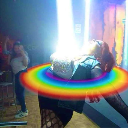 A person leaning backward while a bright beam of light and a rainbow ring emanate from their chest.