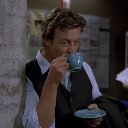 Patrick Jane from The Mentalist sipping from a blue tea cup with a smug expression.