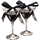 Two martini glasses decorated with black ribbons standing side by side.