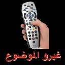 A hand holding a silver remote control with red Arabic text underneath.
