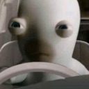 A white Rabbid with wide, blank eyes staring forward while driving.