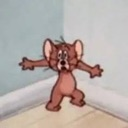 Jerry the mouse standing in a corner with his arms spread wide and a dazed, confused expression on his face.