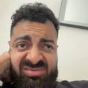 Man making a disgusted, cringing facial expression with a furrowed brow.