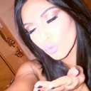 A woman with dark hair blowing a kiss towards the camera.