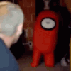 A man with a shocked expression turns to see a person in a red cylindrical costume standing in the dark.