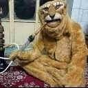 A person in a brown animal mascot costume sitting on a red rug while smoking from a hookah pipe.