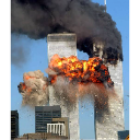 Skyscrapers engulfed in a large orange explosion with thick black smoke rising against a clear blue sky.