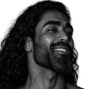 Man with long hair and a prominent jawline smiling confidently in black and white.