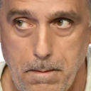 Philippe Poutou looking to the side with a skeptical and judgmental expression.