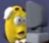 A yellow character with a wide-open mouth looking at a grey computer monitor in shock.