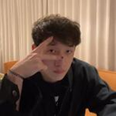 Young man making a peace sign with his hand while looking at the camera.
