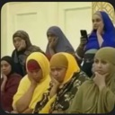 A group of women in hijabs sitting together with bored and unimpressed expressions.