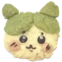 A small round creature with a green mossy top, wide dark eyes, and pink blush on its cheeks smiling gently.