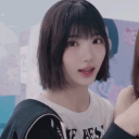 A young woman with short dark hair winks and makes a finger gun gesture at the camera.