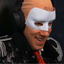 Person wearing a white mask and headphones with a mischievous, smug grin.